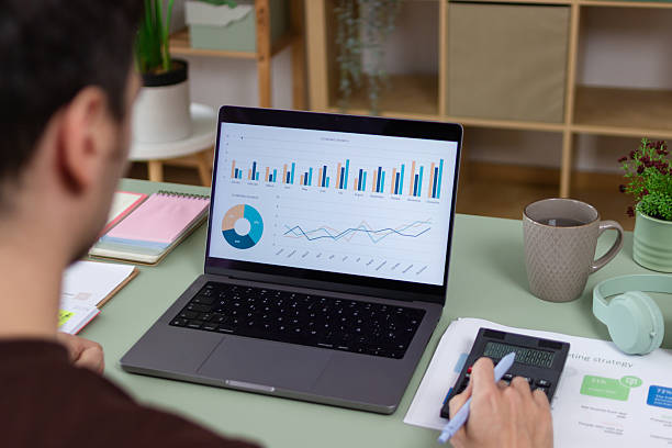 istock Businessman analyzing financial charts and data on laptop in home office 2211705217