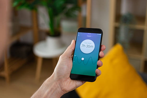 istock Man checking sleep tracking app on smartphone at home 2211705442