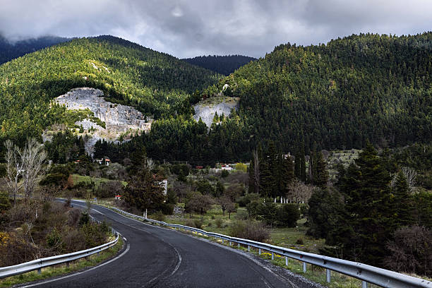 Road trip scene with sunlight and open road with blue sky, rich green mountains and valleys