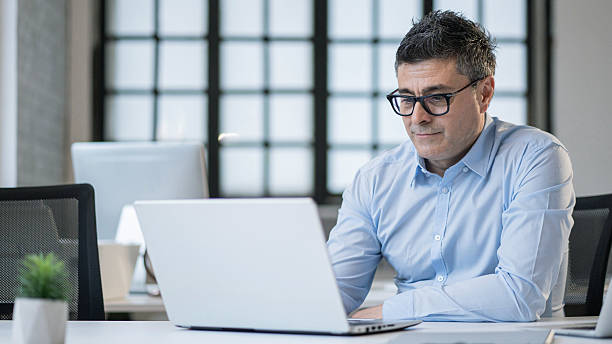 istock Focused business professional analyzing information on laptop, representing productivity and creativity. 2211707385