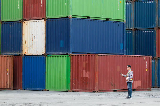 istock Customs clearance officer or shipyard engineer is inspects against the import - export cargo containers. 2211707478