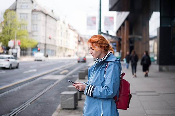 istock Young woman using phone standing at the street 2211709247