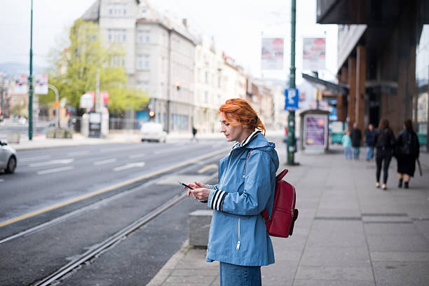 istock Young woman using phone standing at the street 2211709248