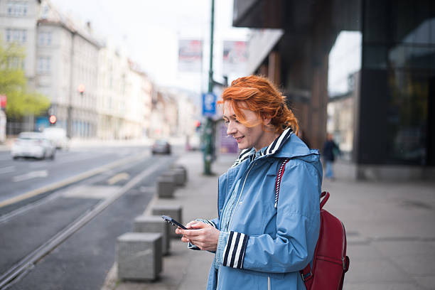istock Young woman using phone standing at the street 2211709281