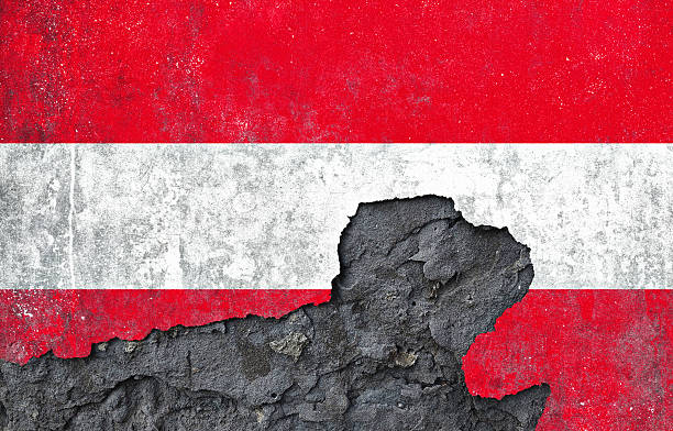 istock Damaged wall with Austrian flag painting on a cracked, textured surface in Austria 2211714783