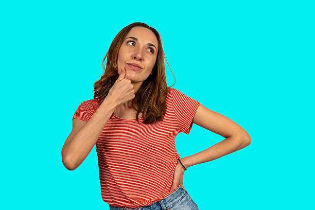 istock Pensive young woman planning and thinking on turquoise background 2211714957