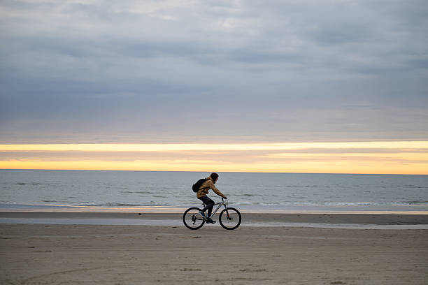 istock man riding bicycle on North sea coast in Denmark 2211715296