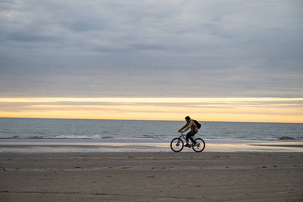 istock man riding bicycle on North sea coast in Denmark 2211715352