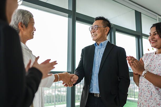 istock Forging Partnerships: Businesspeople Shake Hands in a Modern Office Setting stock photo 2211715870