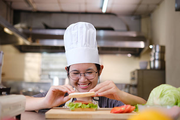 istock Focused chef carefully a gourmet sandwich in a professional kitchen with fresh ingredients in view 2211717332