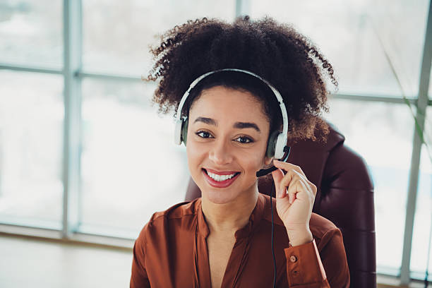 istock Smiling business professional wearing a headset while working in a modern office setting with natural daylight 2211717470