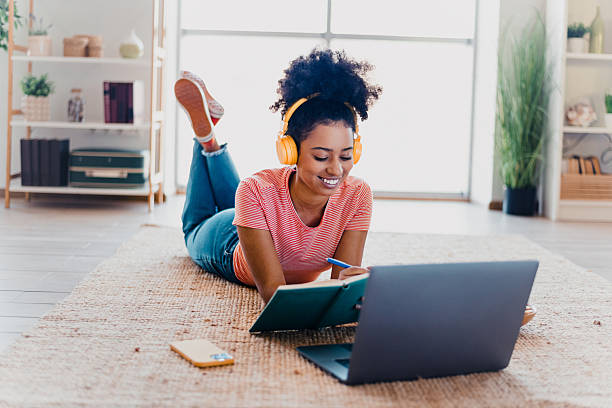 istock Young woman in casual setting studying with laptop, enjoying learning at home while relaxed and comfortable 2211718767