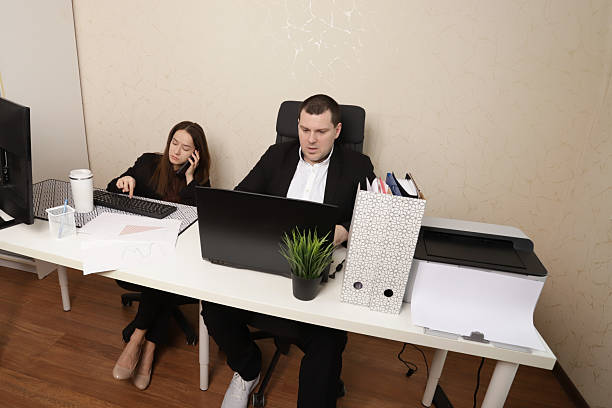 istock Two Office Professionals Discussing Graphs and Business Data in Contemporary Workspace 2211722140