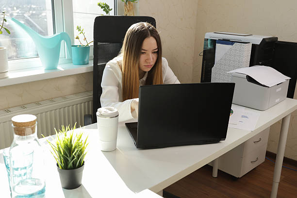 istock Remote Work Concept Featuring Woman Working on Laptop in Cozy Office 2211722155