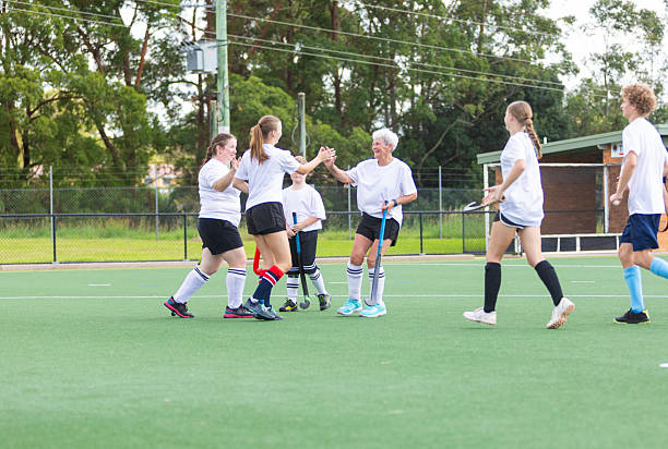 Field hockey team celebrating scoring a goal