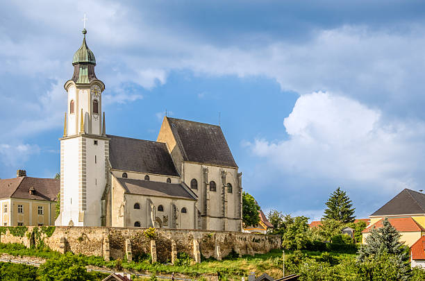 St. Nicholas Church stands majestically in Emmersdorf Austria highlighting its historic architecture amidst the scenic beauty of the Wachau valley. The sky is partly cloudy adding charm.