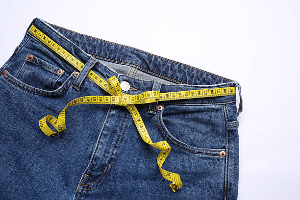 istock Jeans and measuring tape on white background, top view 2211724398