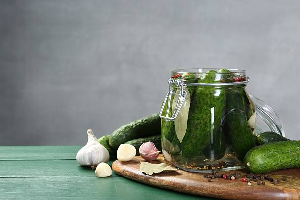 istock Making pickles. Fresh cucumbers and spices in jar on wooden table. Space for text 2211724966