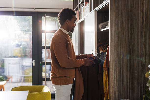 istock Young man sorting his closet and choosing what to wear 2211725122