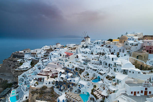 Whitewashed and colorful houses at  volcanic caldera cliff