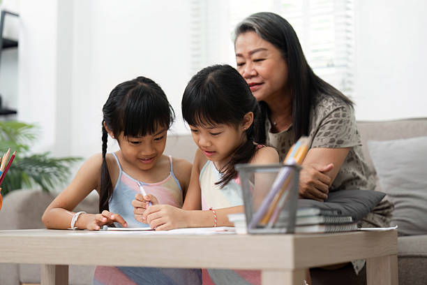 istock Learning and Family Bonding. Two young girls engage in creative activities while their grandmother assists them. 2211727739