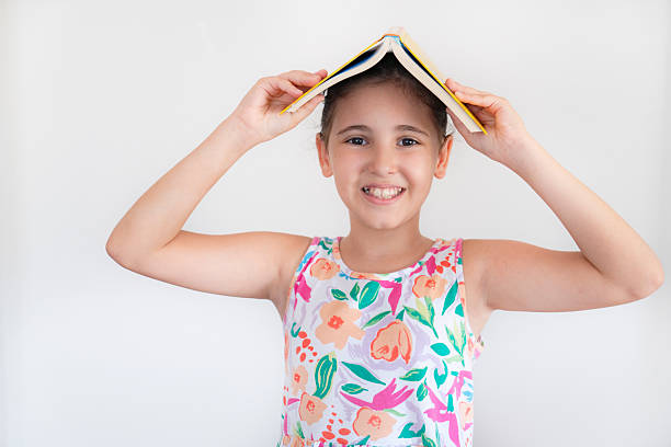 istock Smiling girl with textbook over head 2211728841