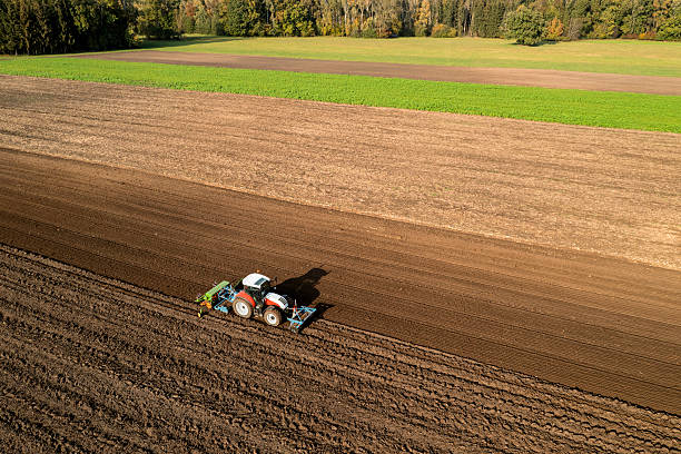 istock Tractor sowing grain in a field 2211728883