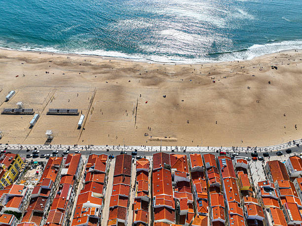 Urban edge of Nazare with beach infrastructure and ocean waves beside it