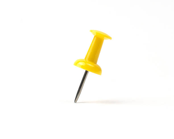 istock Bright yellow push pin stands upright on white background 2211733816