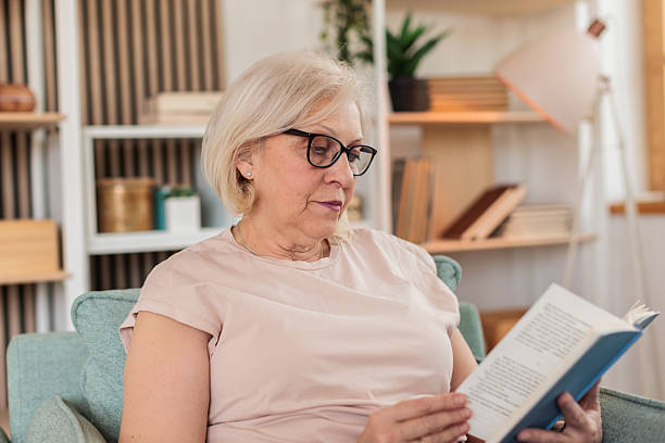 istock Senior woman reading a book at home 2211734607