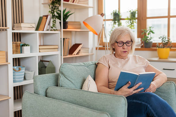istock Senior woman reading a book at home 2211734648