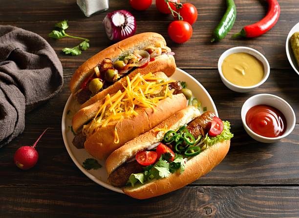 istock Hot dogs with different toppings on wooden table 2211735741