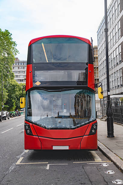 istock Front view of a red London double decker bus, showcasing the sharp design and clean lines. The surrounding urban landscape and buildings reflect in the bus windows. 2211736714