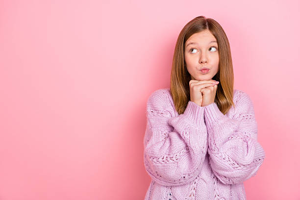 istock Photo of doubtful unsure girl dressed knitted pullover looking empty space isolated pink color background 2211737571