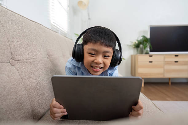 istock Back to School and Learning Fun. A young boy engaged with a tablet, excited about his educational content. 2211737889