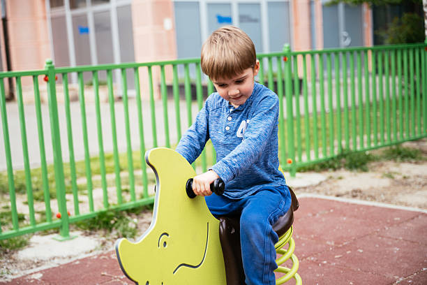 istock Four year old boy playing in the playground outdoors in springtime 2211738014