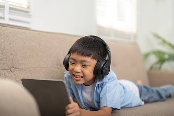 istock Son Enjoying Learning with Technology. A young boy happily engages with his tablet, showcasing modern learning. 2211738077