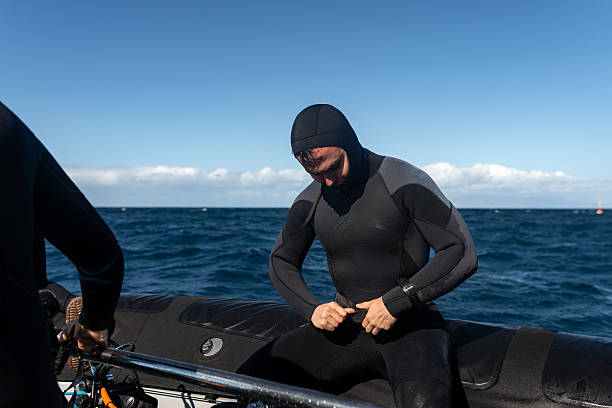 istock Diver preparing his diving suit on a boat in the ocean 2211738444