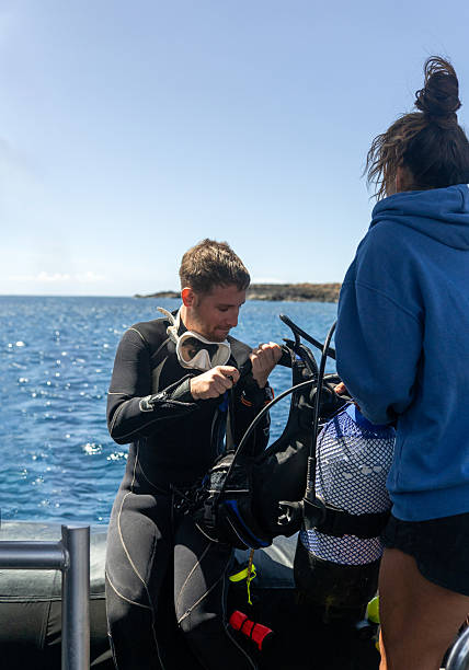 istock Diver preparing equipment on boat with divemaster assistance before scuba diving 2211738589