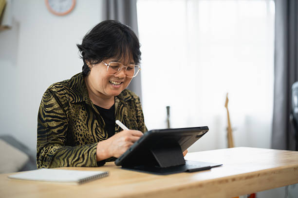 istock Smiling woman using tablet for creative work in modern workspace with natural light and casual attire, showcasing digital lifestyle and productivity 2211740436