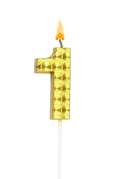 istock Gold birthday candle burning on white, number 1. 2211740657