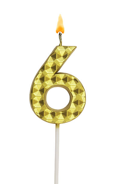 istock Gold birthday candle burning on white, number 6. 2211740683