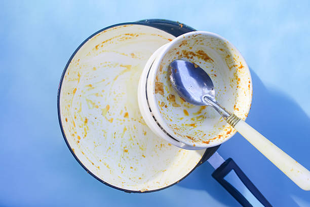 istock pile of dirty dishes on blue background 2211740841