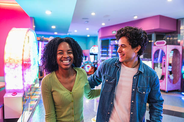 istock Young couple having fun playing in an arcade videogame room 2211743054