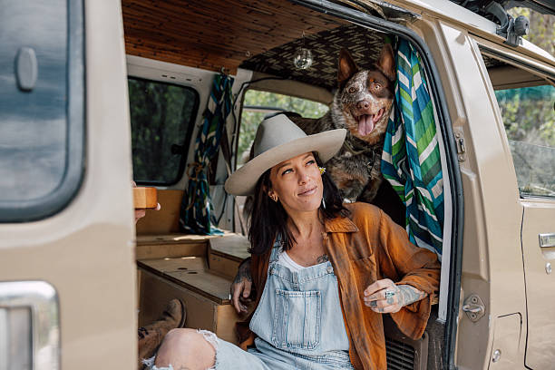 istock Woman and her dog on a mini van camper 2211744136
