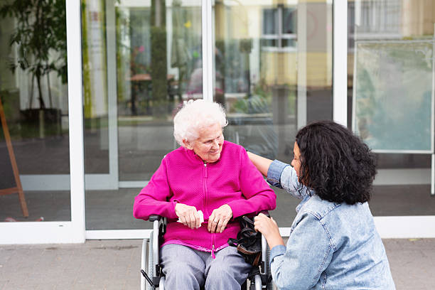 istock kind care for an old senior wman in wheechair 2211744285