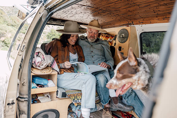 istock Couple on campsite with a vintage minivan 2211744297