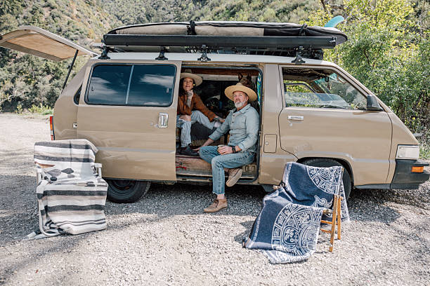 istock Couple on campsite with a vintage minivan 2211744395