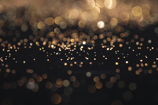 istock Beautiful shiny golden glitter on black background, closeup 2211745821