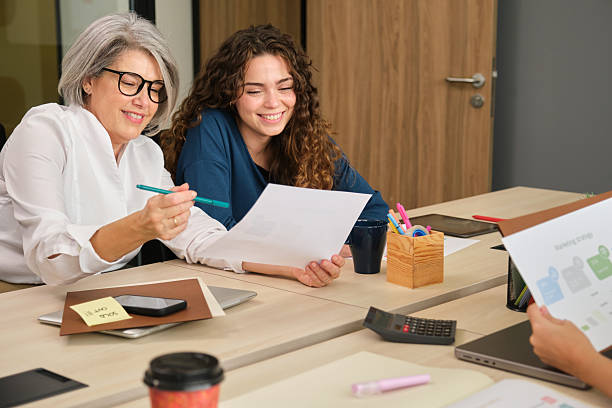istock Two businesswomen collaborating on a project, analyzing documents at office desk 2211746328